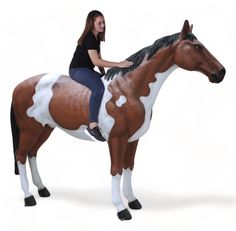 a woman sitting on the back of a brown and white horse with black manes