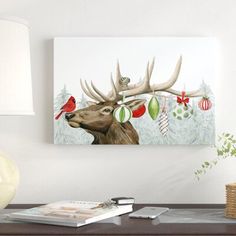 a painting of a deer with christmas decorations on it's antlers and a bird