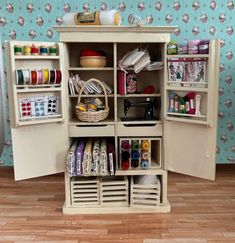 an open cabinet with sewing supplies on it