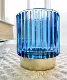 a blue glass vase sitting on top of a table