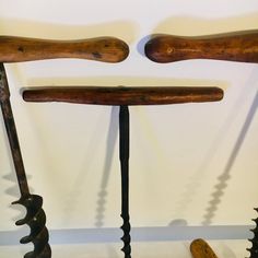 three wooden tools are lined up against the wall