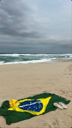 a flag and flip flops are laying on the beach