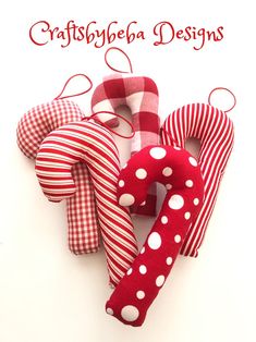 three red and white fabric heart ornaments with the words craftsbybe designs on them