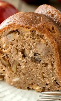 a close up of a piece of bread on a plate with an apple in the background