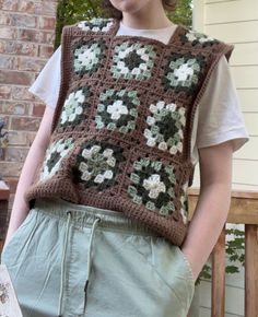 a woman wearing a crocheted vest with flowers on it