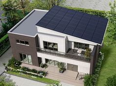 an aerial view of a modern house with solar panels on the roof and two balconies