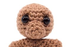 a brown crocheted stuffed animal with black eyes