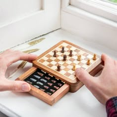 two hands playing a game of chess on a table