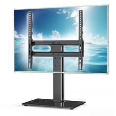 a flat screen tv sitting on top of a metal stand with an ocean scene in the background