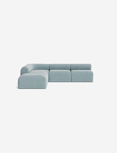 a blue sectional couch sitting on top of a white floor