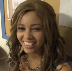 a woman with long hair smiling at the camera