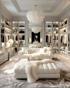 a large white couch sitting in front of a walk in closet filled with lots of clothes