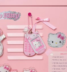 hello kitty cell phone charms are displayed on a pink background with other items in the foreground