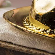 Miniature Gold Brass Cowboy Hat. Whether you are a cowboy or cowgirl, this Miniature Brass Cowboy Hat guarantees to bring a smile to the western lover in all of us!    Let this tiny accessory reside in your wee dollhouse world or sit upon your personal life-size desk! Use as a special western themed party favor. Add it to your fairy garden, terrarium, or dioramas.    Miniature collectors and crafters, alike, will appreciate its detailed features, and antiquated finish.    Dollhouse miniatures ar Gold Fedora Hat For Rodeo, Gold Fedora Western Hat, Gold Western Fedora Hat, Gold Short Brim Hats For Country Events, Gold Brimmed Hat For Rodeo, Gold Western Hat Band For Western-themed Events, Western Gold Brimmed Hat, Gold Western-style Hat Band For Western-themed Events, Western Gold Fedora With Short Brim