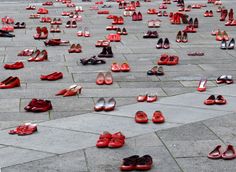 many pairs of red shoes lay on the ground