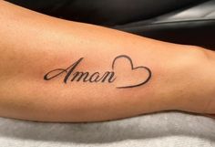 a person with a tattoo on their arm that reads aman and has two hearts in the middle