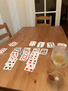 image shows playing cards on a kitchen table along with a bottle of wine Solitaire Game, Card Game Table, Book Vibes, Summer To Do List, Table Games, Card Game, To Do List