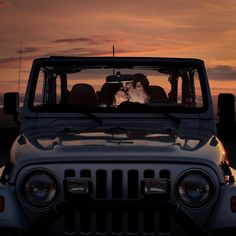 two people are kissing in the back of a jeep at sunset with their heads turned towards each other