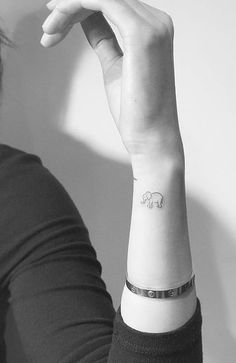 a woman with a small elephant tattoo on her wrist