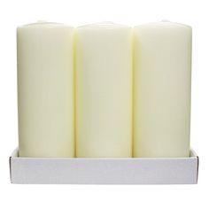 three white candles in a box on a white background