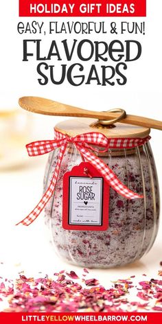 a jar filled with lavender sugar next to a wooden spoon and red ribbon on top