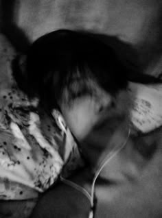 a blurry image of a person laying on a couch with headphones in their ears