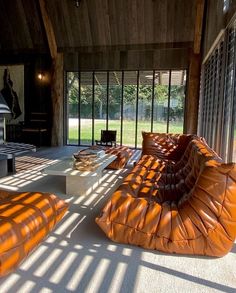 an orange couch sitting on top of a white floor next to a fire place in a living room