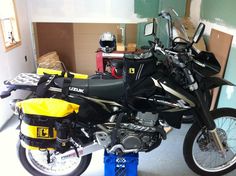 a motorcycle parked in a garage next to some boxes and other things on the floor