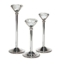 three silver candlesticks with diamonds on them