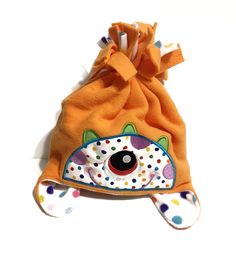 "An adorable handmade toddler-sized embroidered monster hat in a double layer of fleece with ear flaps.  The cute embroidered monster face is on orange fleece while the inside layer is lots and lots of polka dots. Such a special, warm and unique hat for your little one!  One size made to fit most children measuring up to approximately 22\".  The hat measures approximately 7\" top to bottom and approximately 20\" around with a little stretch.  Because it is a handmade item, there will be slight v Hat For Boys, Boys Hat, Monster Hat, Orange Fleece, Grandmothers Love, Monster Face, Fleece Hat, Unique Hats, Boy Hat