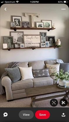 a living room filled with furniture and framed pictures on the wall above it's coffee table