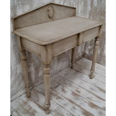 an old wooden table with two legs and a drawer on the top is sitting against a wall