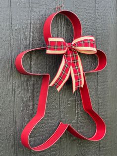 a christmas ornament hanging on the side of a wooden door with a bow