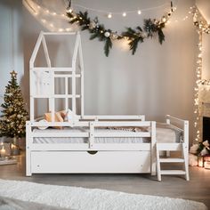 there is a white bed with a ladder on the bottom and a christmas tree in the background