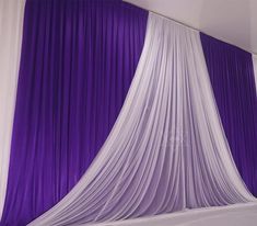 purple and white drapes draped over a bed