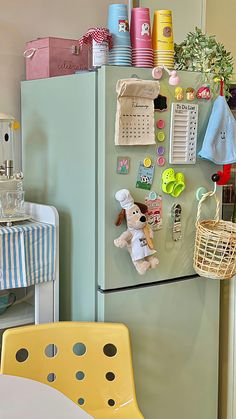 a refrigerator with magnets on it and a yellow chair