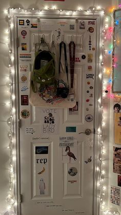 a white door covered in lots of stickers and magnets next to a wall