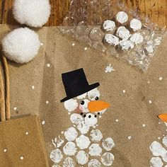 a paper bag with a snowman made out of white pom - poms