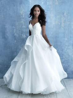 a woman in a white wedding dress posing for the camera with her hands on her hips