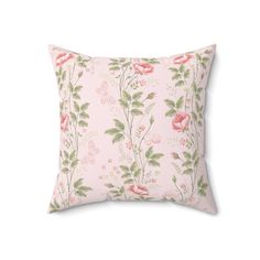 a pink floral pillow with green leaves and flowers on the front, against a white background