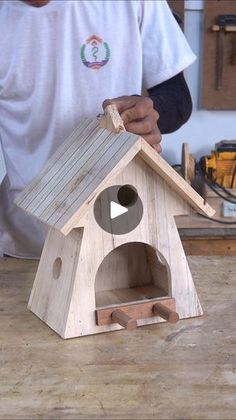 a man is making a birdhouse out of wood