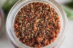 a jar filled with spices sitting on top of a table next to another container full of seasoning