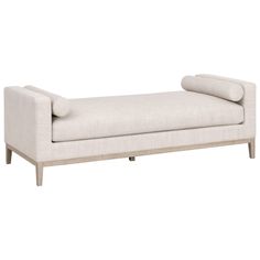 an upholstered bench with two pillows on it's back and arms, against a white background