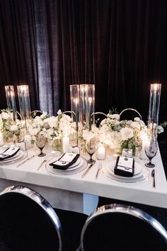 the table is set with candles, flowers and place settings for an elegant dinner party