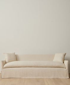 a white couch sitting on top of a hard wood floor