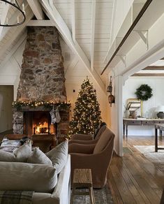 a living room filled with furniture and a christmas tree in front of a fire place