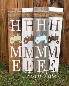 three wooden signs with farm animals painted on them, sitting in the grass next to a fence