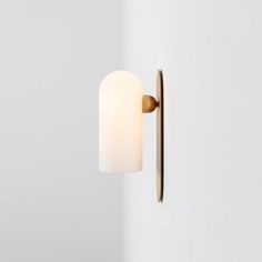 a light that is on the wall next to a door handle and a white wall