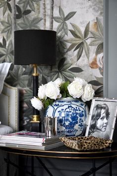 a table topped with pictures and flowers next to a lamp