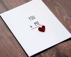 a piece of paper with a red heart on it and the words you + me